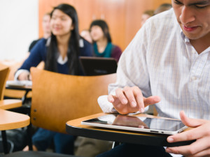 College students taking notes in lecture hall