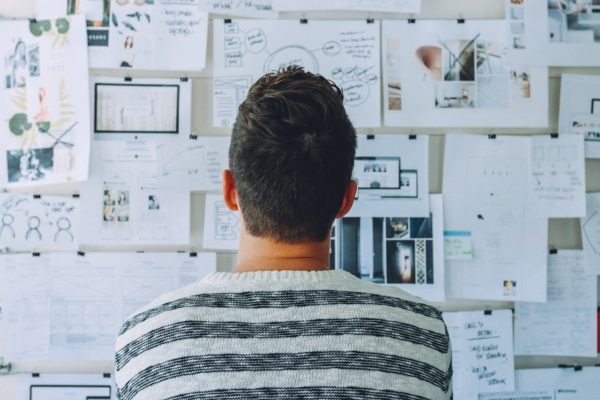 young man stares at a wall of research