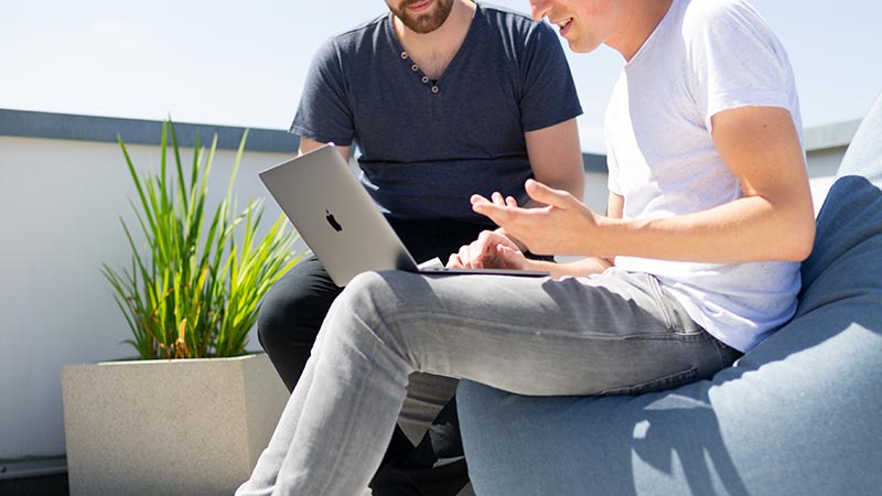 unpatched vulnerable laptop with two individuals viewing content