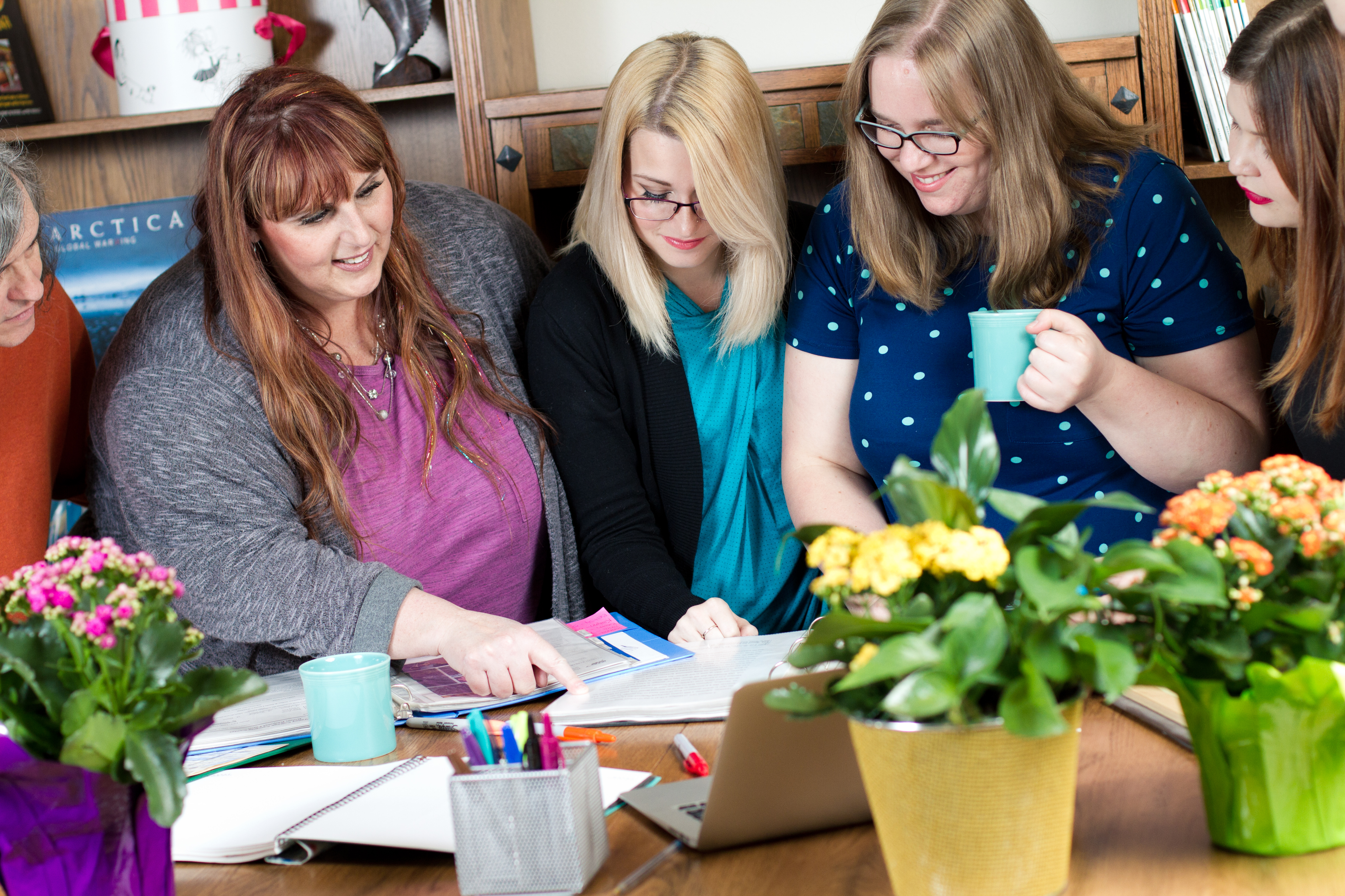 Three Girls Medias team of content marketers looking at documents together
