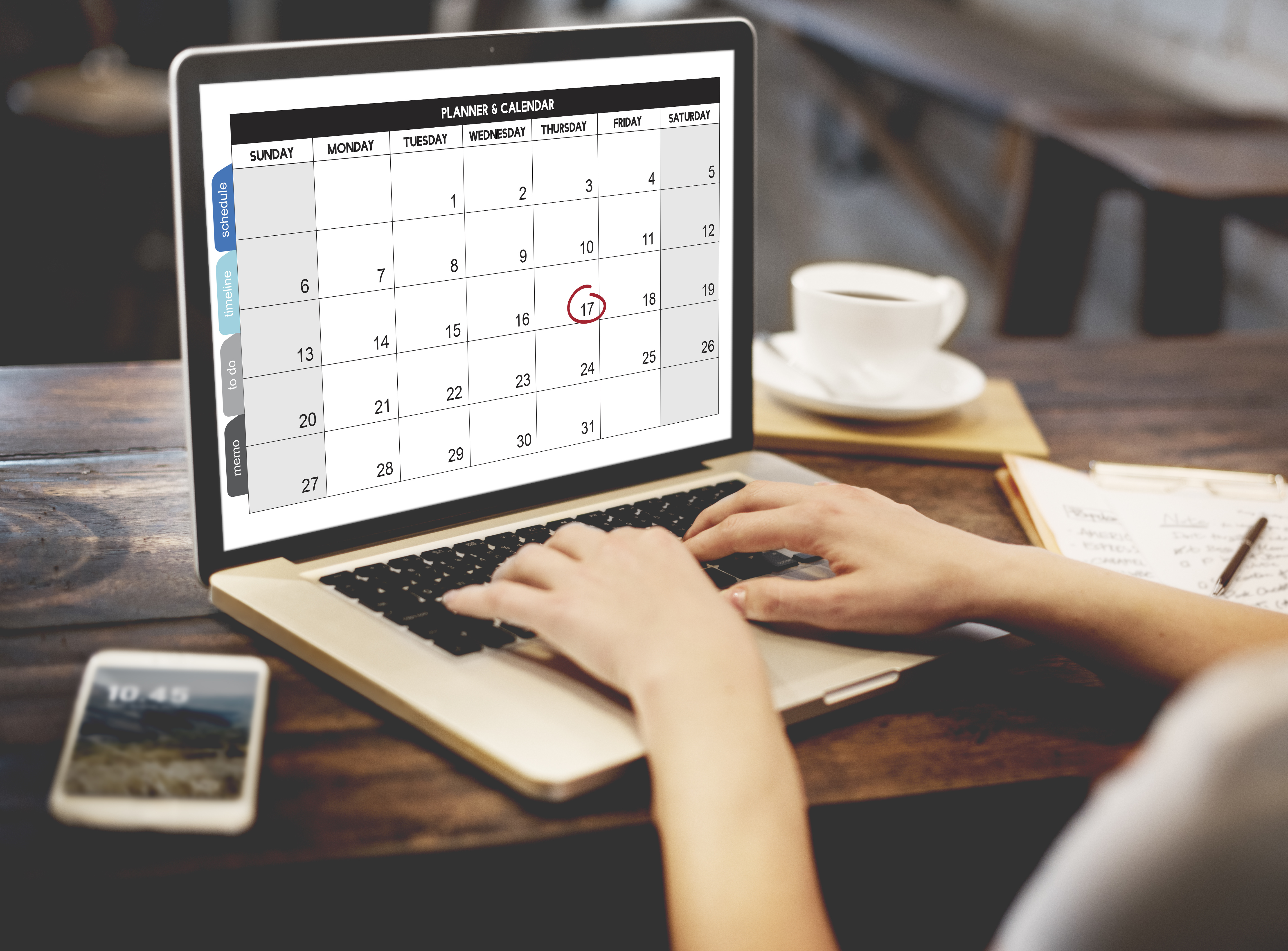 Person typing on laptop and scheduling on a calendar