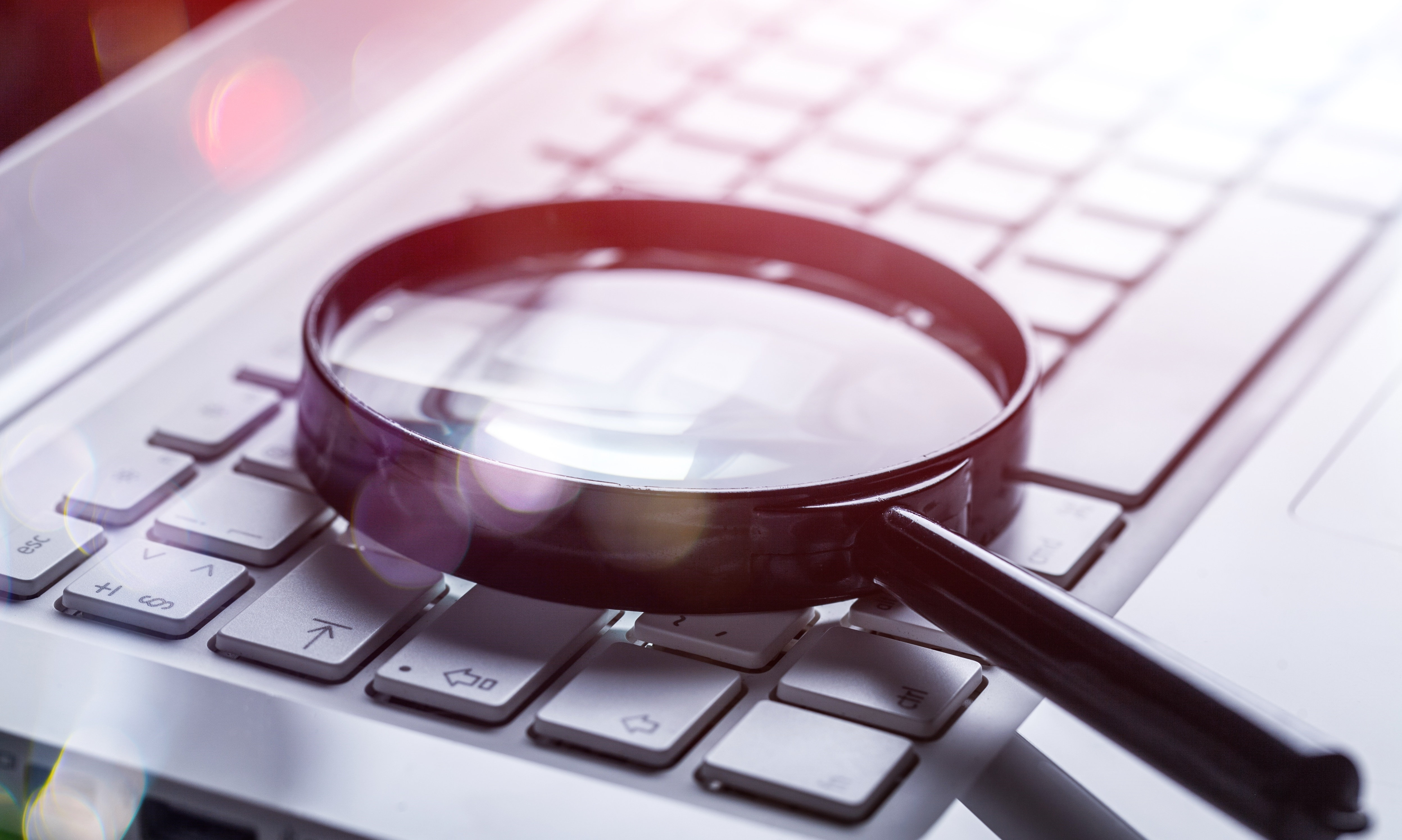 Magnifying glass on keyboard for business blogging SEO