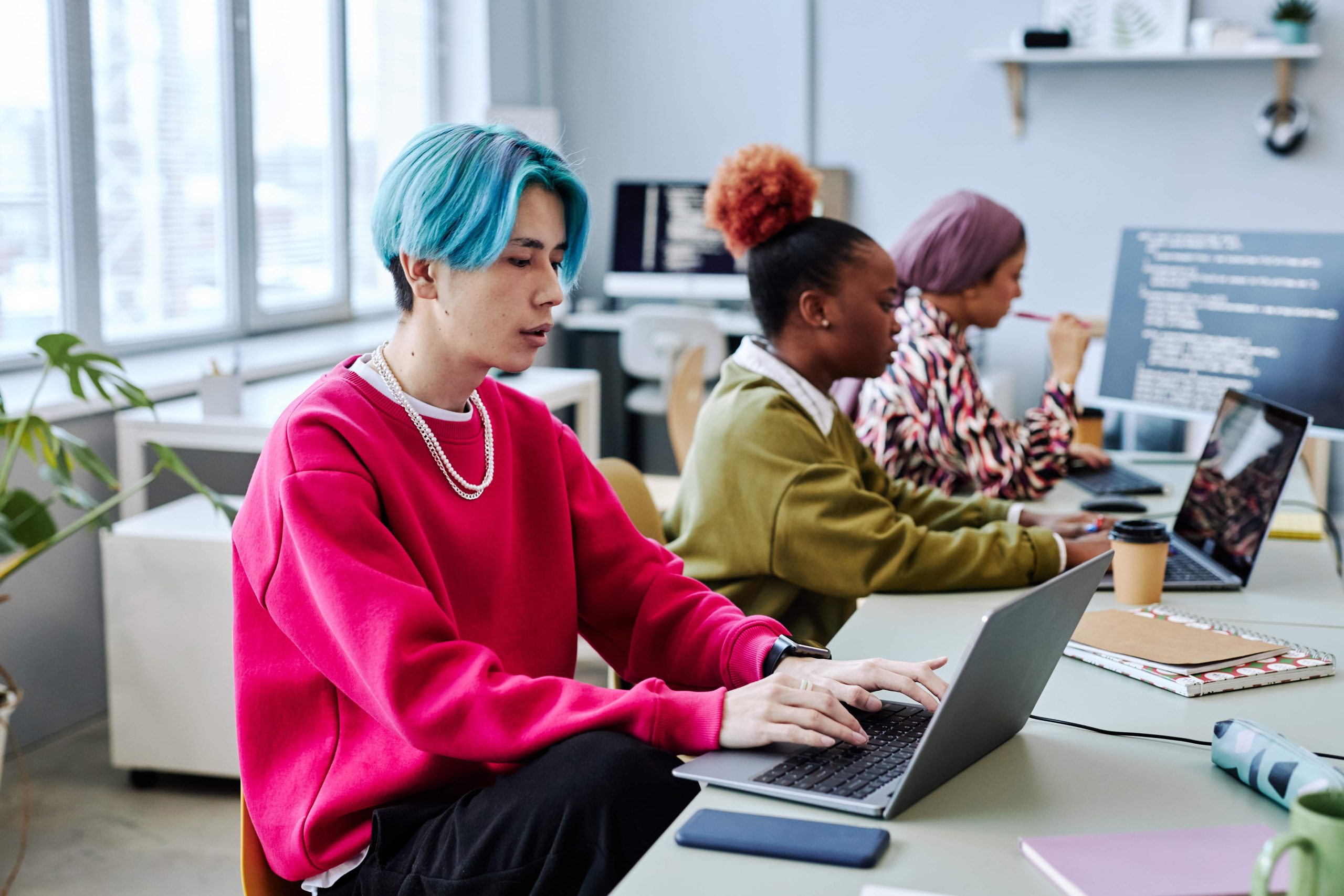 3 young people working on laptops at a table