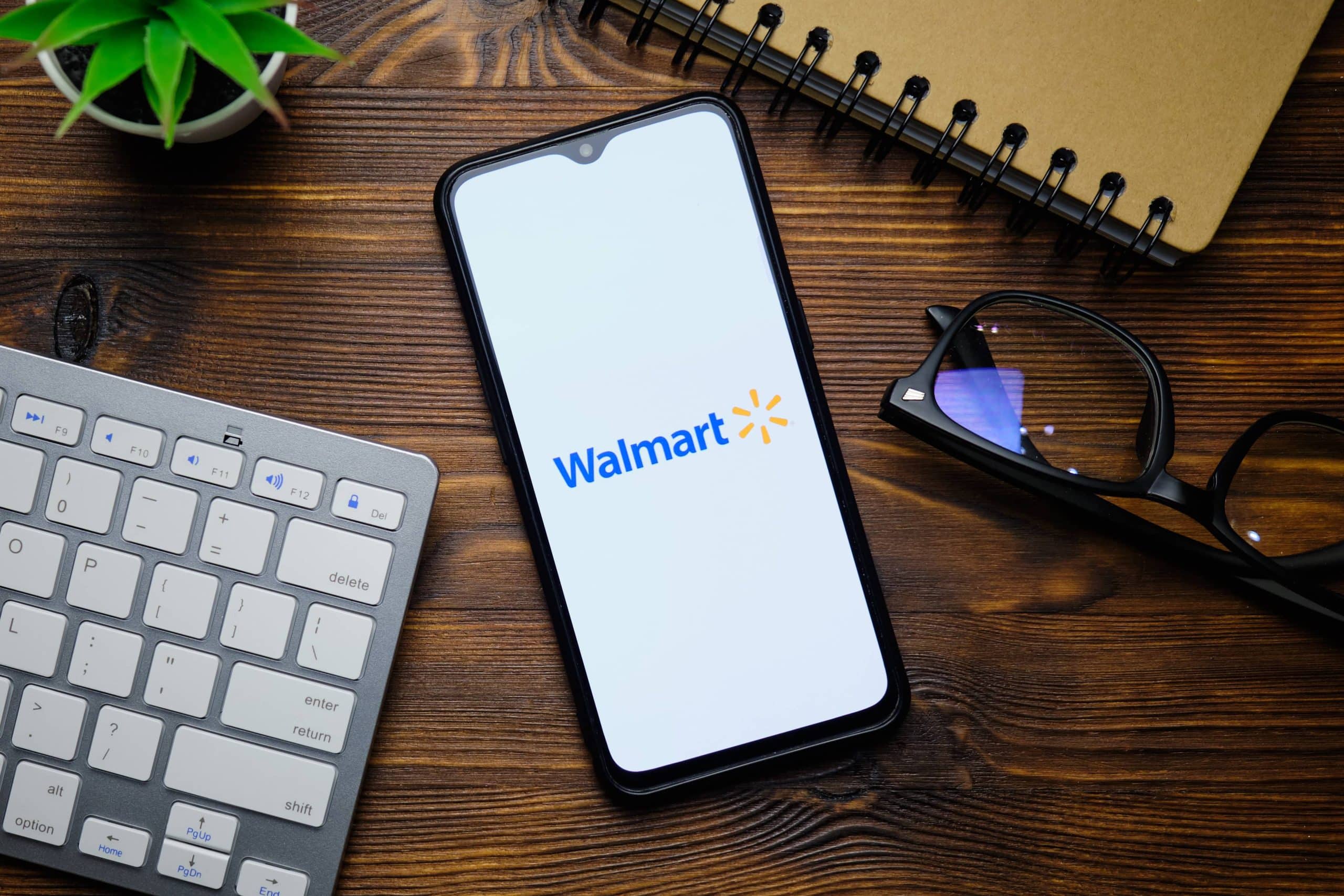 walmart on a phone next to glasses and a keyboard