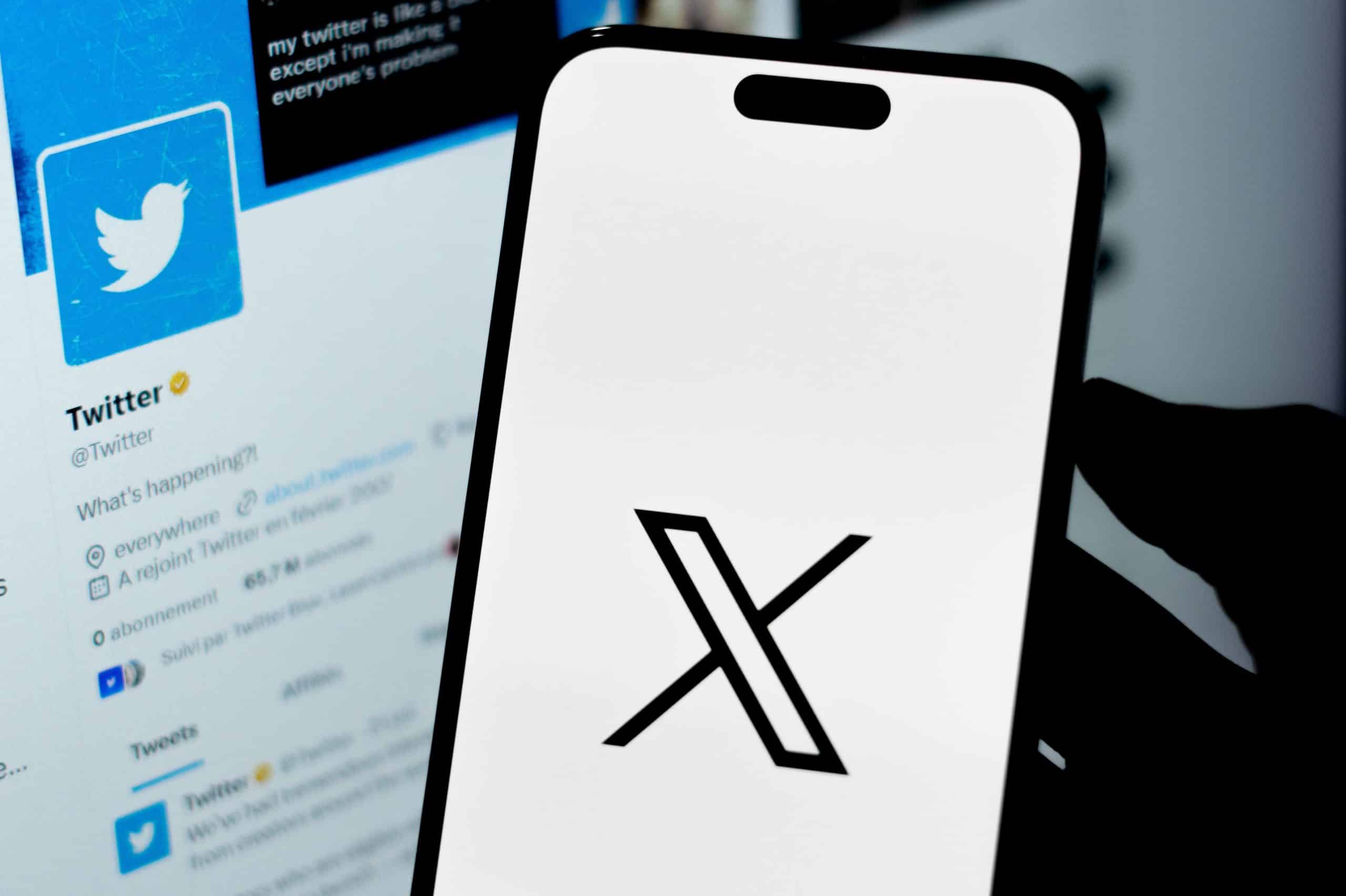 X on a phone next to a screen with Twitter