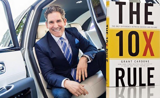Grant Cardone in a car next to his book