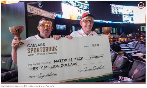 Mattress Mack with a big check