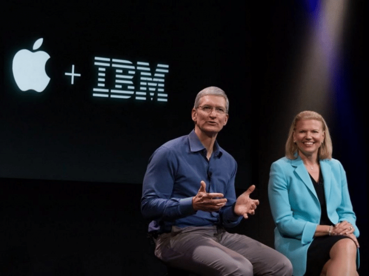 Tim Cook with a woman on a stage with an Apple and IBM logo in the background