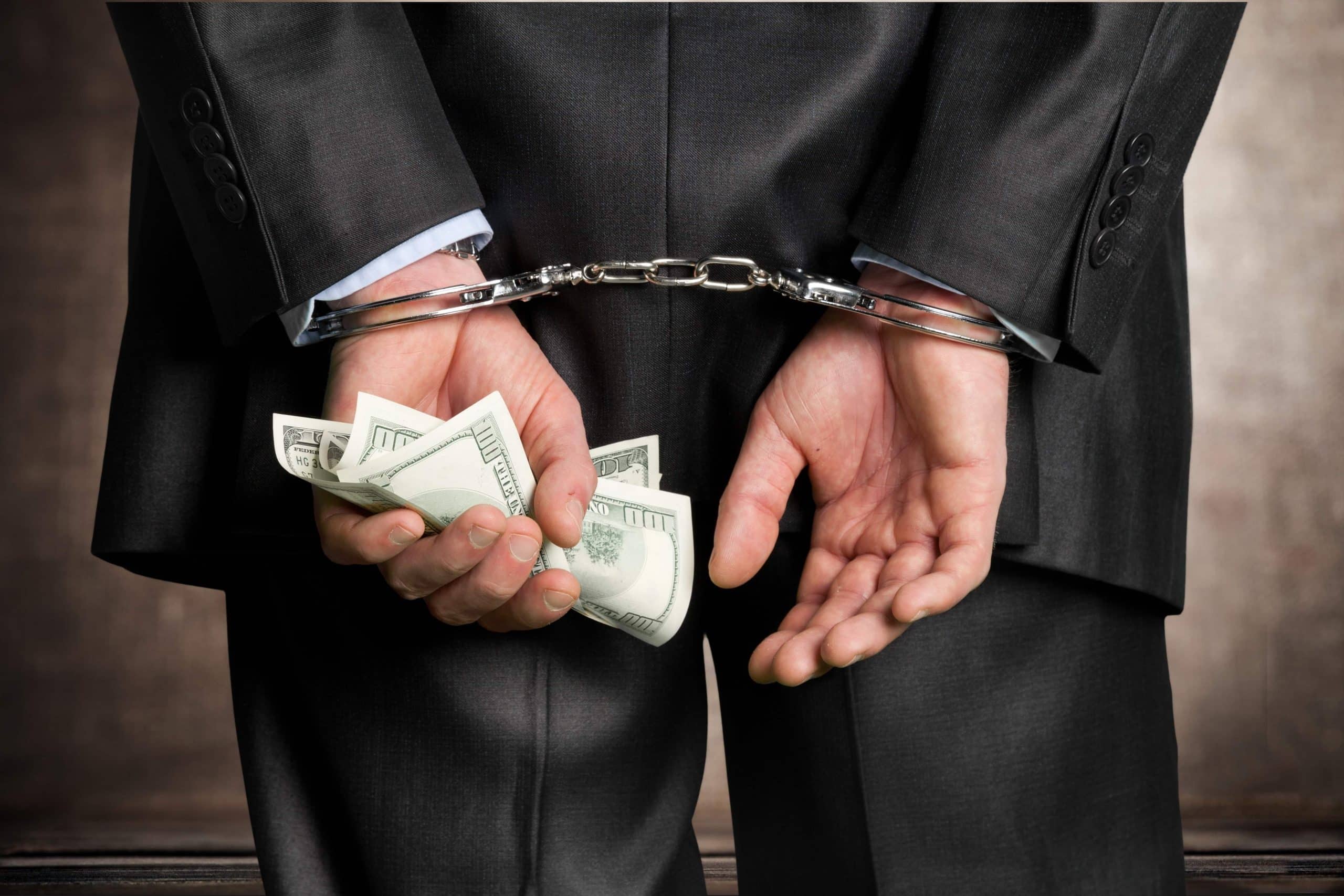 handcuffed man with money in his hand