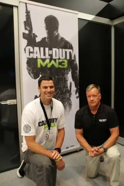 Dr Disrespect kneeling with a colleague
