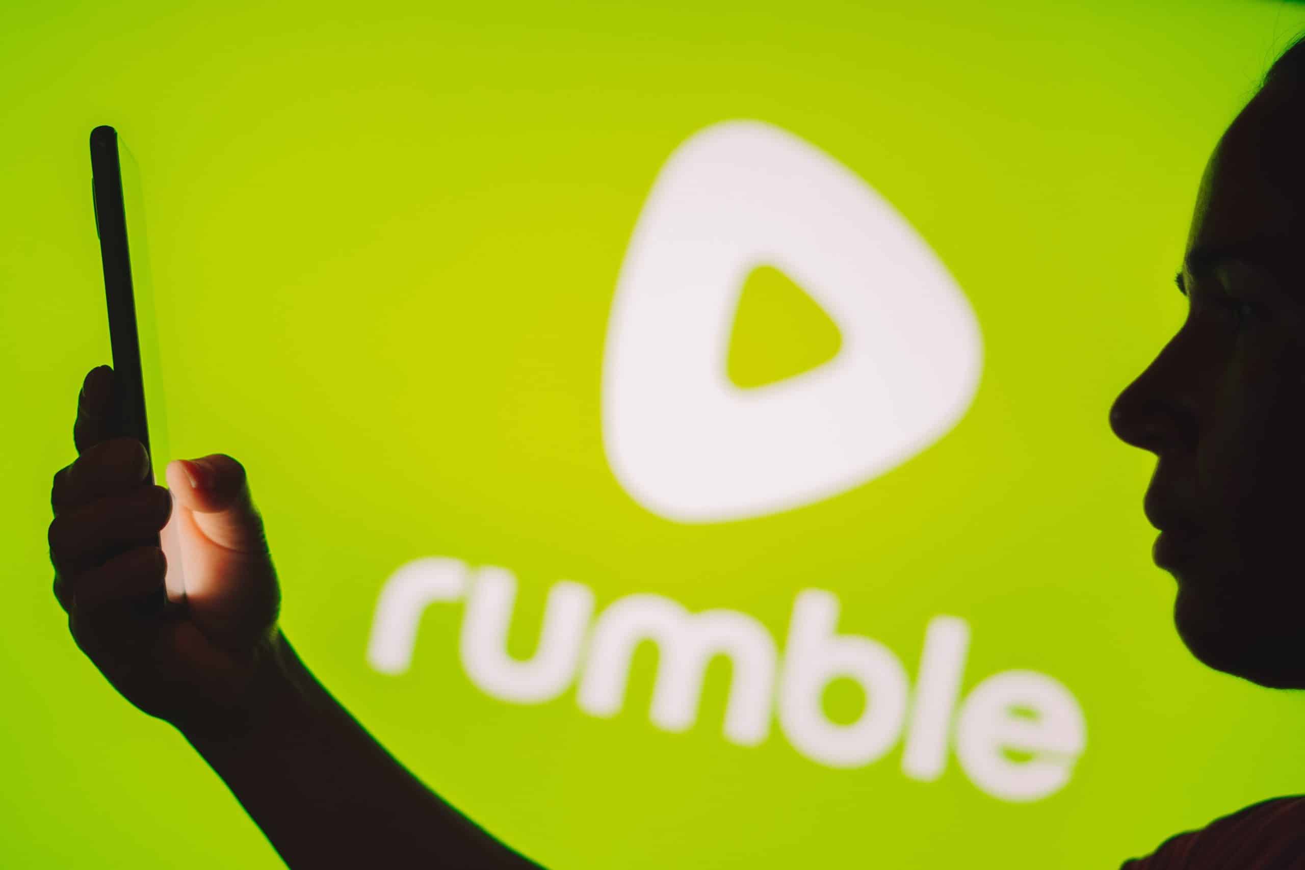 person on phone in front of Rumble logo